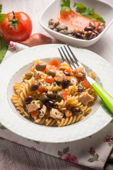 pasta with fresh salmon tomatoes capers and olives, selective focus