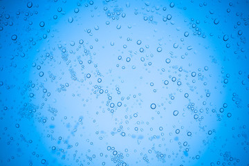 Rain droplets on blue glass background, Water drops on glass.