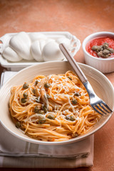 spaghetti with mozzarella tomato and capers, selective focus