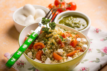 couscous with mozzarella tomatoes and pesto sauce, selective focus