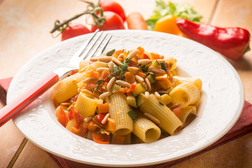 pasta with mixed vegetables and pine nuts, selective focus