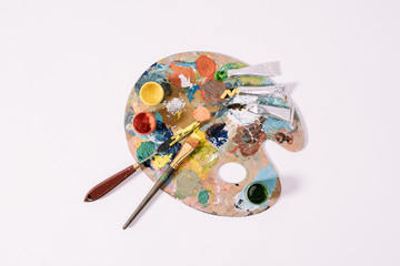 top view of palette with colorful paints isolated on grey