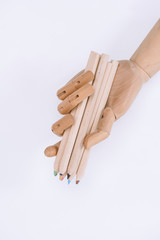 close-up view of mannequin holding colorful crayons isolated on white