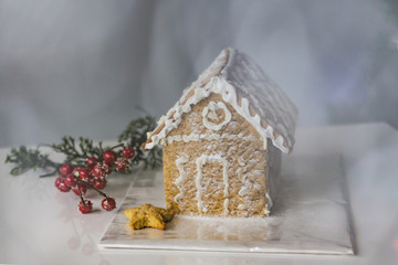 Christmas cookie houses. European tradition, homemade Christmas decoration. Snow whirlwind and Christmas tree in background. Shallow depth of focus. Concept traditions.