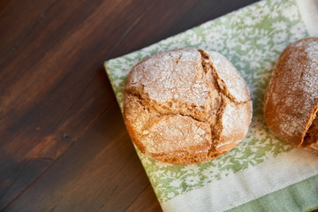 Freshly baked hand-made bread on a kitchen towel. Space for lettering.