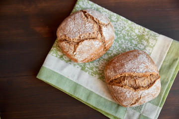 Freshly baked hand-made bread on a kitchen towel. Space for lettering.