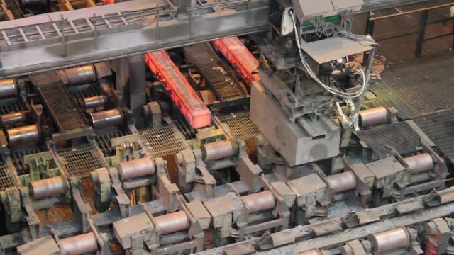 Continuous casting machine showing red hot freshly cast blooms emerging.