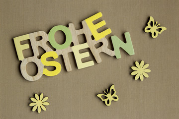 FROHE OSTERN Schriftzug Blüten und Schmetterlinge in Naturfarben auf Hintergrund aus lehmfarbigem...