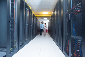 engineer showing working data center server room to female chief