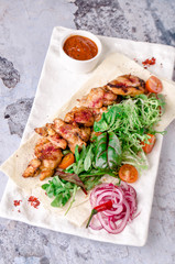 top view delicious Bbq meat with vegetables, sauce spices chile on gray concrete background. with ketchup on white plate, view from above