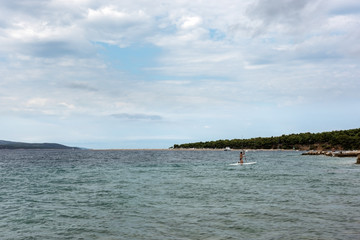 Fototapeta premium Adult man floats with the surfboard on the sea
