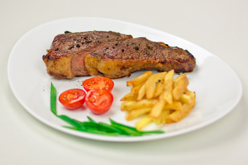 Delicious beef steak with fries and tomatoes