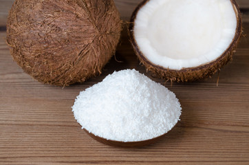 coconut flakes in a bowl on wooden background