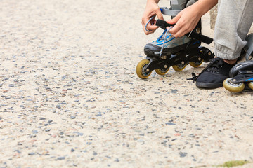 Woman putting on roller skates outdoor.