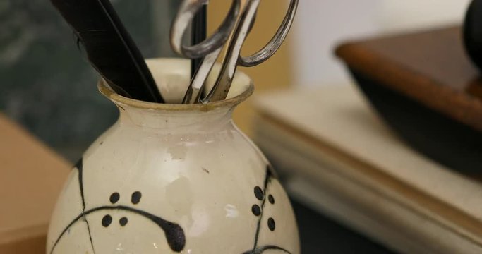 Scissors and feather in vase