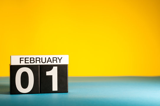 February 1st. Day 1 of february month, calendar on yellow background. Winter time. Empty space for text