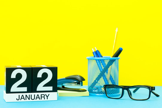 January 22nd. Day 22 of january month, calendar on yellow background with office supplies. Winter time
