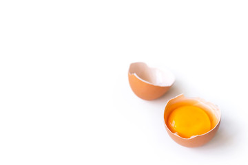 fresh brown organic chicken egg broken with yolk and egg white isolated on white background. Horizontal composition.