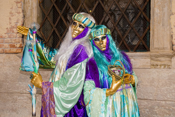 Obraz premium Venice Carnival - Lovely Couple of Venetian masks in colorful and elegant costume on St. Mark's Square in Venice.