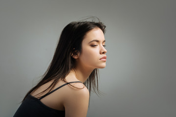Preoccupied. Beautiful serious long-haired young woman thinking and looking in the distance and...