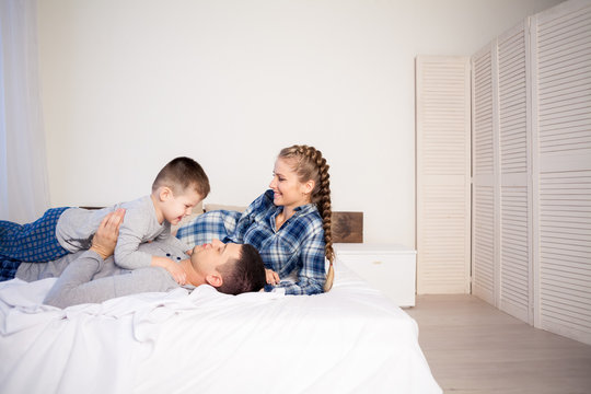 Mom Dad And Son In The Morning Lying On The Bed At Home