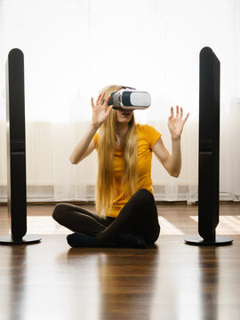 Girl wearing virtual reality goggles at home