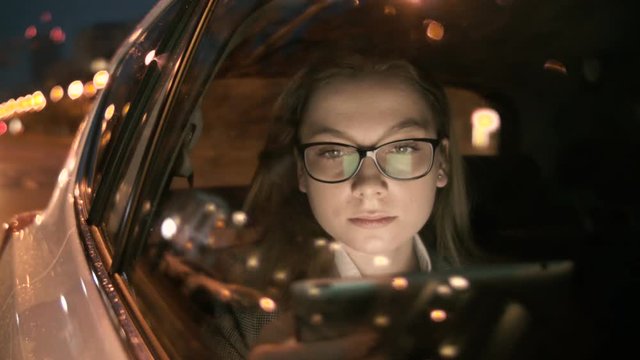 Young Woman Using a Tablet Computer in the Moving Car