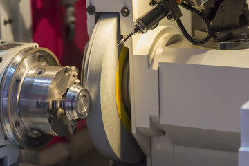 The cylindrical grinding machine with the steel part .Hi precision manufacturing concept.