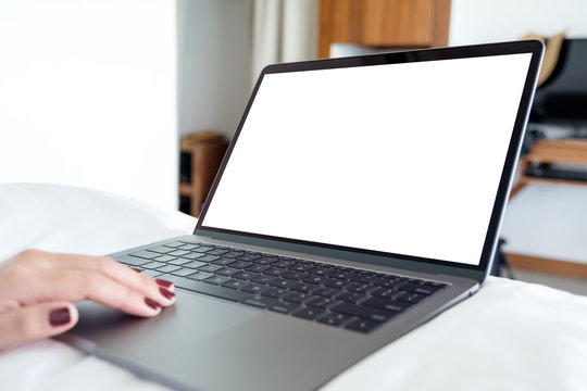 Mockup image of woman's hands using and touching on laptop with blank white desktop