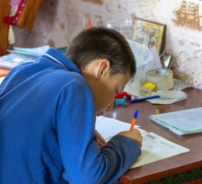 11 Year Old Boy Teenager Doing School Homework On Mathematics