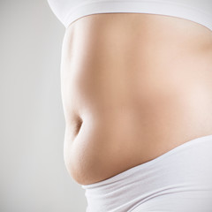 Side view of woman with fat belly. Obesity concept.