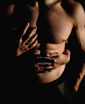 Woman holds her hands on man's naked chest