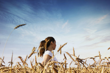 Happy woman in wheat field. The concept of freedom and unity with nature