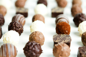 PRALINE CHOCOLATE IN LINE. SWEET DESSERT STILL LIFE ON WHITE BACKGROUND