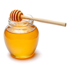 Glass can full of honey and wooden stick on a white background. clipping path