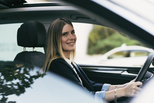 Woman in car agfter parking looking at camera and smiling