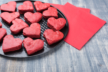 Obraz na płótnie Canvas Red velvet heart cookies on plate. Baking tray with sweet biscuit cakes. Valentine days food