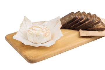 Slices of black rye bread with sunflower seeds lie on a wooden board next to cheese.
