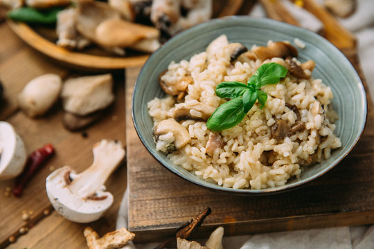 Risotto with mushrooms on an old wooden background. Rustic style.