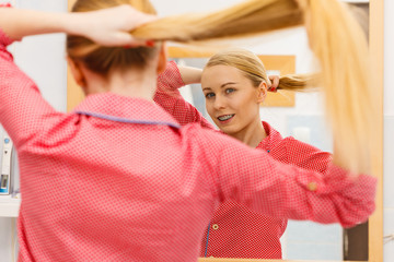 Woman combing her long hair in bathroom