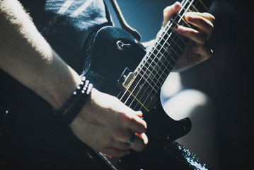 Close up of lead guitarist performing a solo on stage during concert - obrazy, fototapety, plakaty