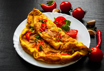 omelette in a plate on dark wooden background