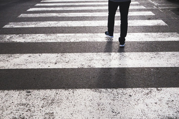 low section of a pedestrian crossing the road from the marked crosswalk
