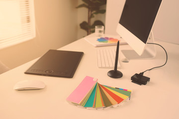Modern office workplace with desktop computer, stylus and tablet for retouching