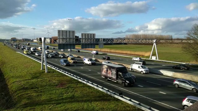 Traffic jam on Dutch highway A12, ambulance riding on emergency lane, passing slow traffic.
