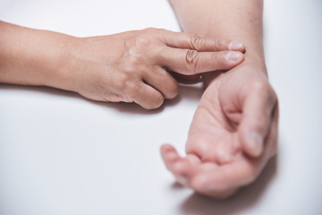 Asian Senior Female checking her pulse.