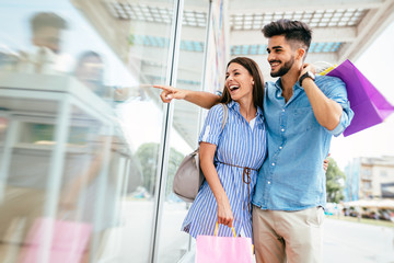 Happy attractive loving couple enjoy shopping together