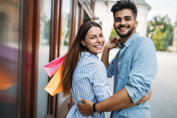 Happy attractive loving couple enjoy shopping together