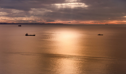 Obraz premium Seascape with ships and cloudy sky at sunset.
