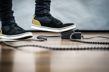 Naklejka premium Man using guitar effects pedal